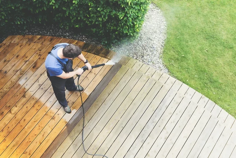 Man pressure cleaning a wooden deck