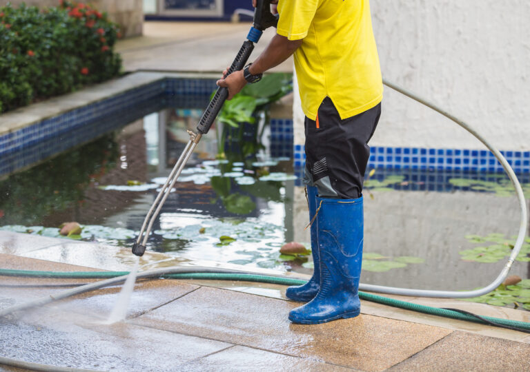 Man high pressure cleaning a surface