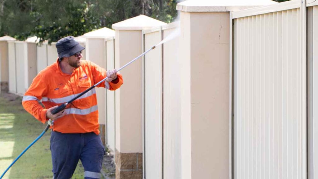 Member of Pressure washed south east qld pressure cleaning a white colourbond fence.