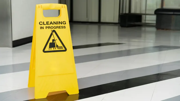 A yellow warning Sign saying cleaning in progress. The sign is on a clean tile floor