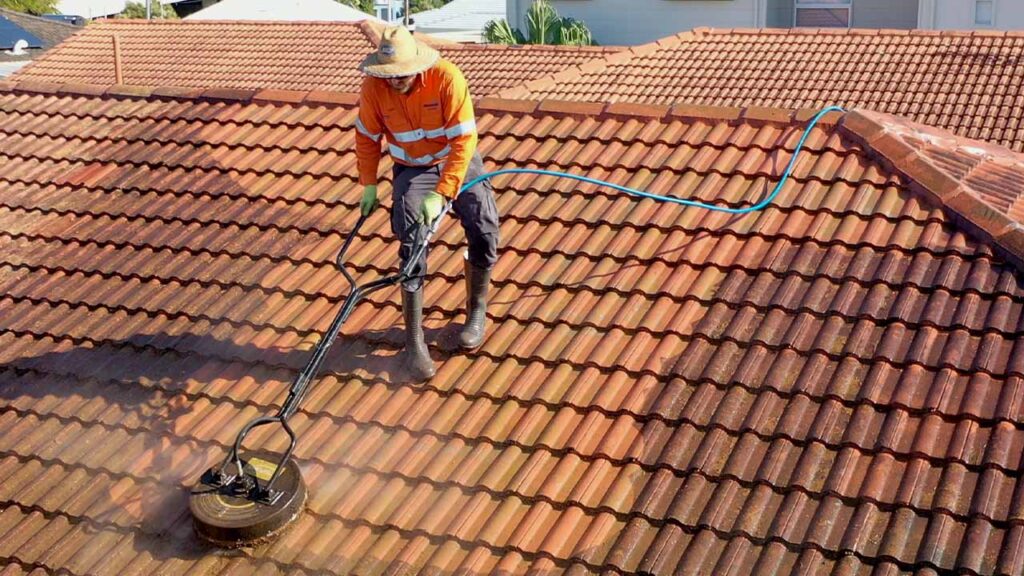 Member of Pressure Washed South East QLD cleaning a tile roof with a rotary cleaner