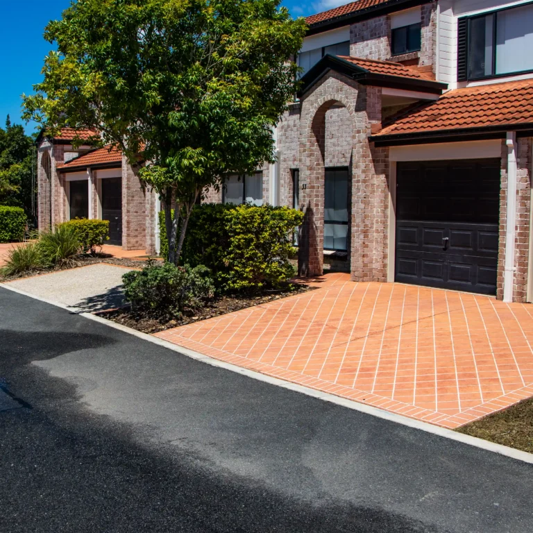 Photo of an two apartments that have just been pressure cleaned. The apartments are moden brick with red tile roofs and red tile driveways