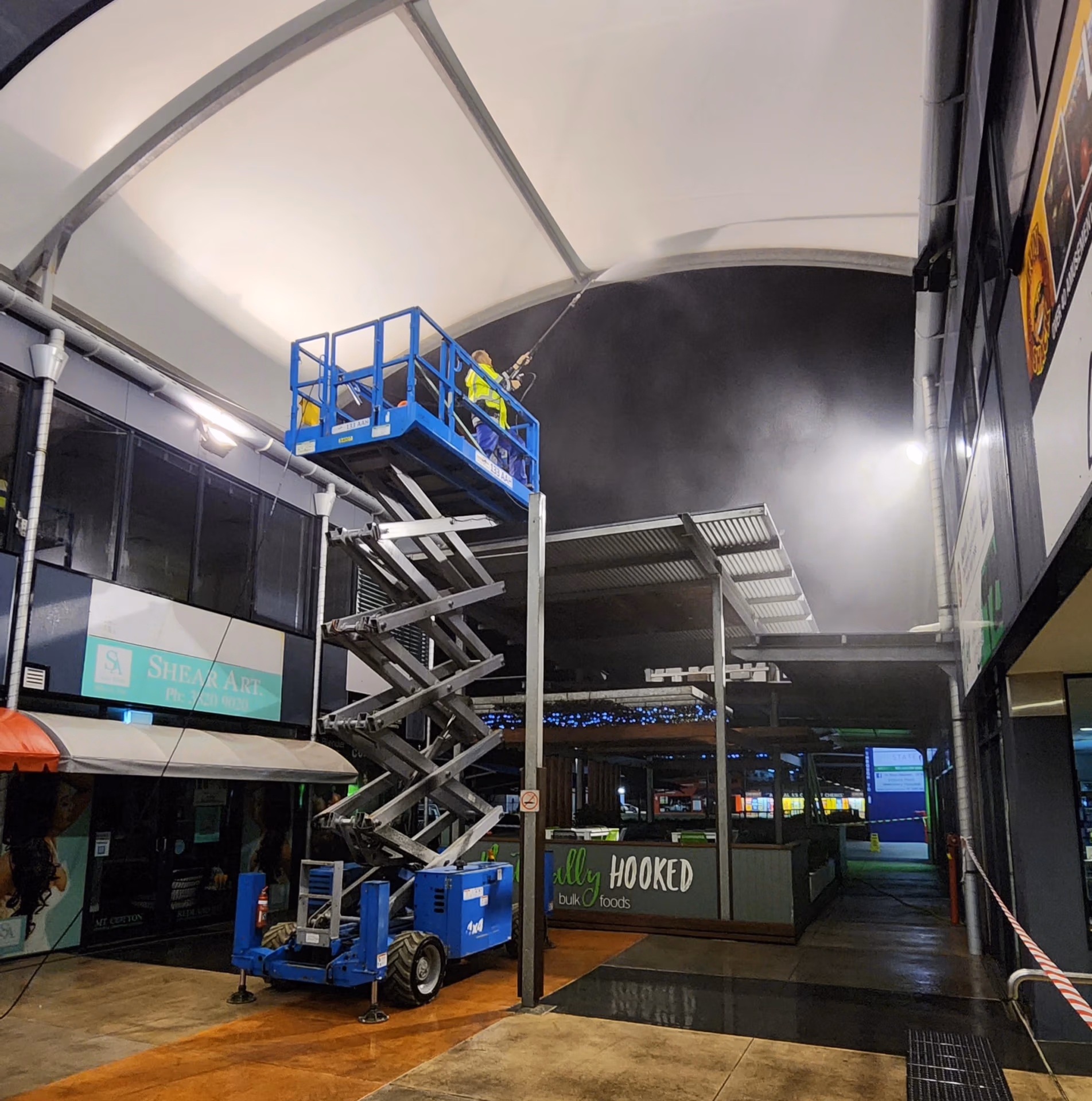Pressure washed south east qld team member pressure cleaning a roof using a scissor lift.