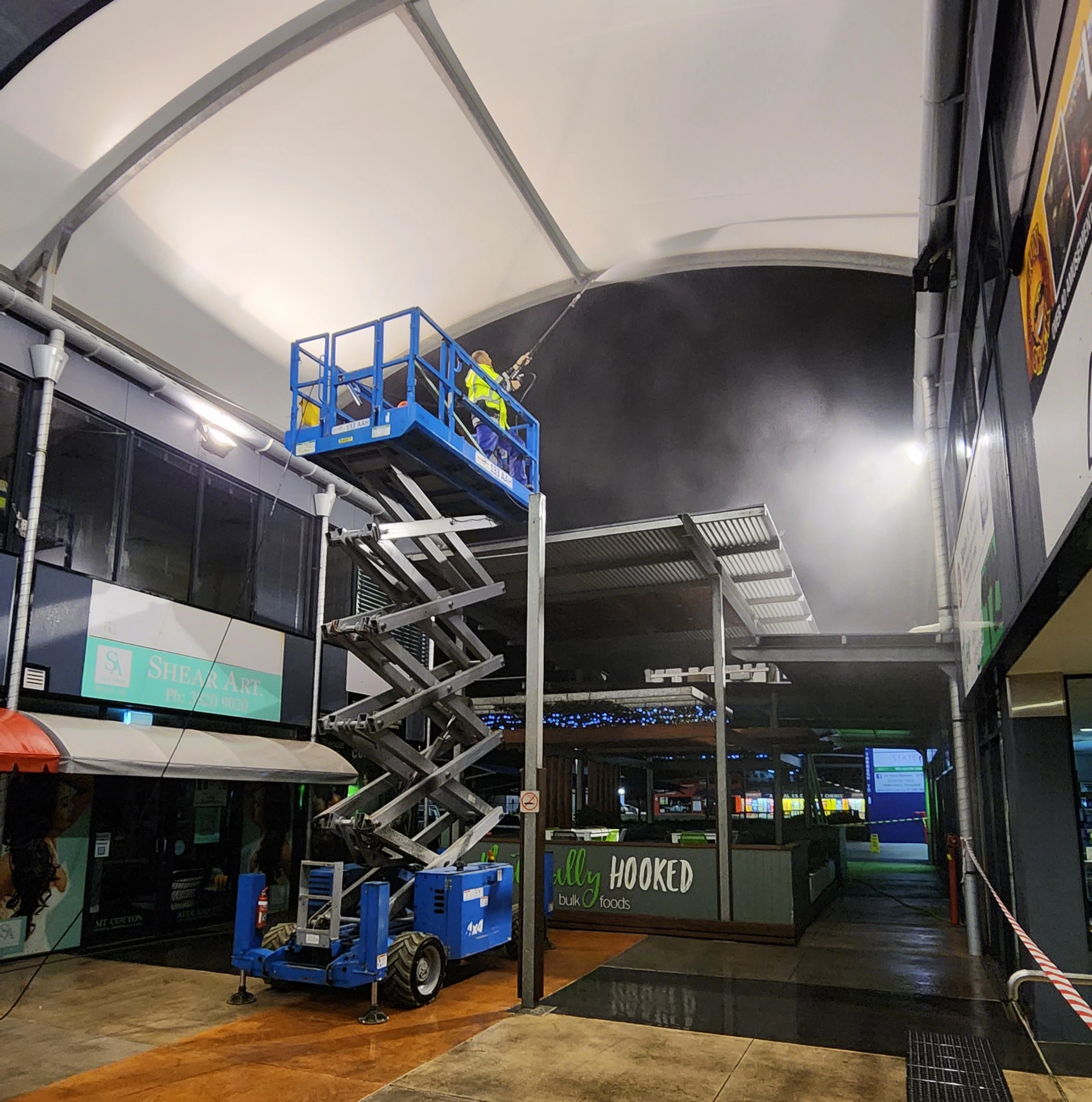 Pressure washed south east qld team member pressure cleaning a roof using a scissor lift.