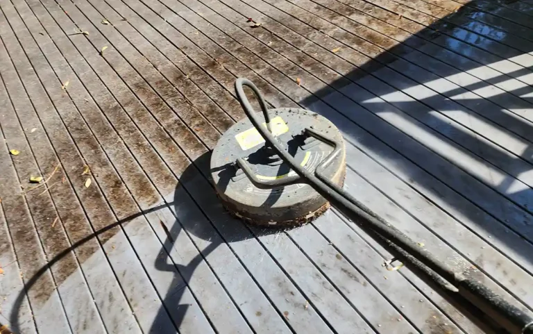 A rotary surfaces cleaner that is cleaning a dirty wooden surface. Have the surface is clean and half the surface is still dirty.