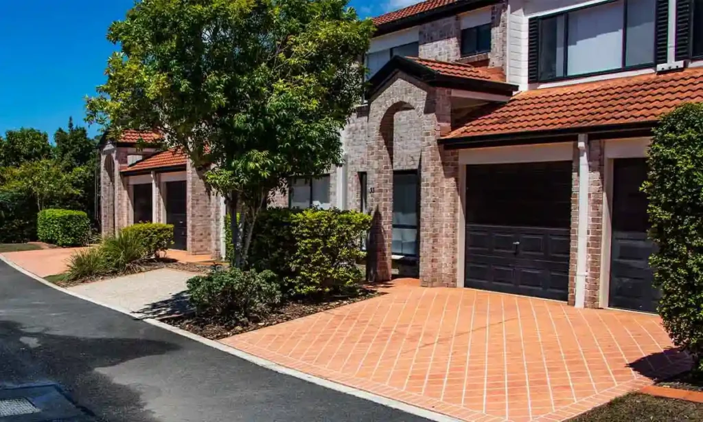 Photo of a Body corporate managed street in an apartment complex. The street has just been cleaned by Pressure Washed South East QLD. It's a bright sunny day and water can be seen on the ground.